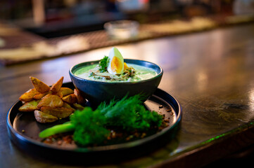 Summer soup okroshka with egg, vegetables, sausage, herbs, potato and kefir in bar