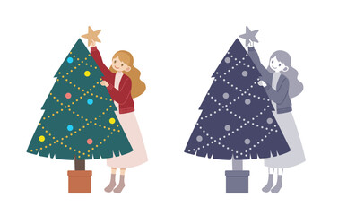 クリスマスツリーに星を飾る女性