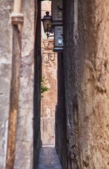 Travel destination. Old street in city with road and stone buildings. Beautiful narrow street with paving stones in the old city.