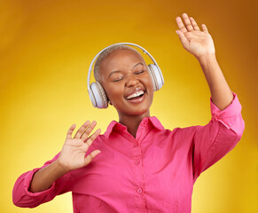 Happy, music headphones and black woman dance in studio isolated on a yellow background. African...