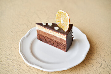Chocolate sponge cake, with mousse, decorated with Orange slice and meringue. Breakfast in the cafe, morning coffee. on wooden table.