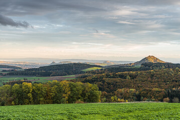 Fototapeta na wymiar Panoramic view over the autumn volcanic landscape Hegau with the Hohenkraehen, Hohentwiel and Hohenhewen, on the horizon the Swiss Alps, Baden-Wuerttemberg, Germany