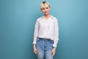 portrait of successful young pretty blond business woman in white blouse and jeans on background...