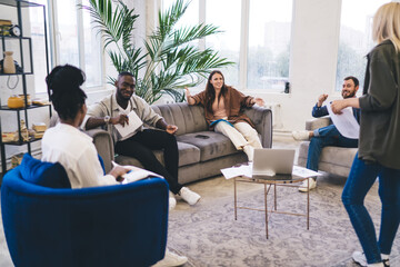 Fototapeta premium Happy diverse coworkers communicating in spacious office