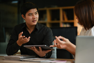 Male and female interior designers are having a planning meeting to discuss interior design.