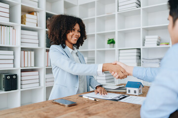 The bank's Female African american Mortgage Officers shake hands with customers to congratulate them after signing a housing investment loan agreement