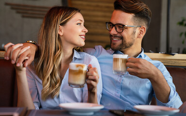 Romantic loving couple drinking coffee, having a date in the cafe.