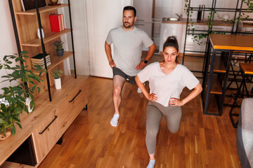 Couple doing lunges while working out at home