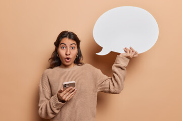 Shocked woman holds speech bubble showcasing her desire for self expression alongside smartphone...