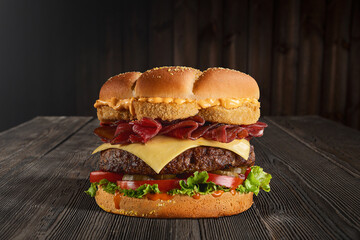 cheese beef burger sandwich closeup on a rustic wooden surface