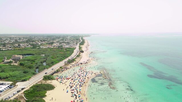 vista aerea della spiaggia di San Pietro in Bevagna. Paesaggio estivo con la spiaggia e gli ombrelloni colorati. Salento, Puglia, Italia