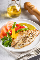 Grilled tilapia fillet with spices and colored peppers.