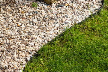Gravel and lawn in home garden. Gardening concept background. Lawn edge close up summer