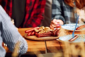Wooden plate with many tasty sausages and pretzels on table with foamy lager beer glasses. Appetizers for alcohol drink. Concept of oktoberfest, traditional taste, friendship, leisure time, enjoyment