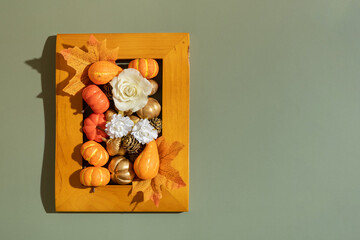 Golden frame with pumkins, roses and maple leaves. Autumn minimalist aesthetic concept