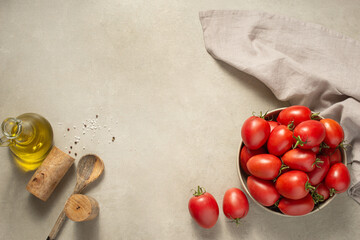 Culinary background. Tomatoes in a plate, spices and oil on a gray background