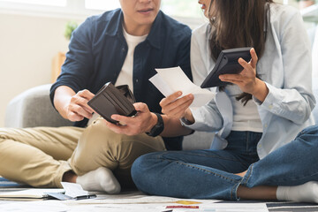 Stressed financial owe asian young couple love sitting stressed and confused by hand hold wallet...