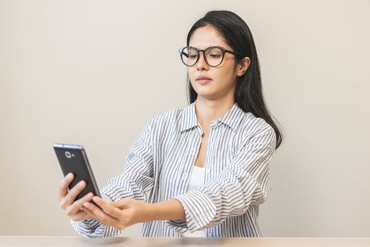 Presbyopia, Hyperopia Middle Aged Asian Woman Holding Eyeglasses Problem With Vision Blurred ,trying To Read Text Message From Smart Mobile Phone Screen, Eye Disease Of Old, Eyesight Farsightedness.