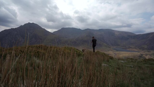 A photographer filming a beautiful mountain scene in North Wales