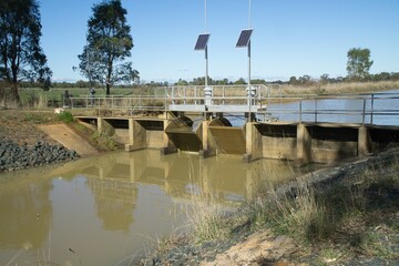 Irrigation water flow regulator and control gates that are remotely controlled and solar powered on a man made channel.