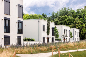 Multifamily Residential Apartment Building with Lanscape Design. Modern White High rise Buildings with Perennial Plant Flowers and Greening Landscape. Estate sale.