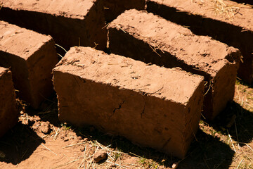 Man building with his hands an adobe house with adobe bricks and mud. Llachon region of Lake Titicaca in Peru.