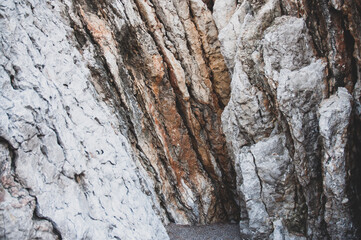Brown, red, and white rock texture with cracks. Close-up. Stone granite background.