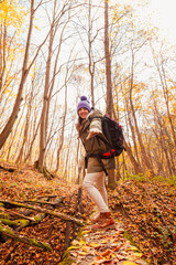 Woman having fun spending autumn day hiking outdoors