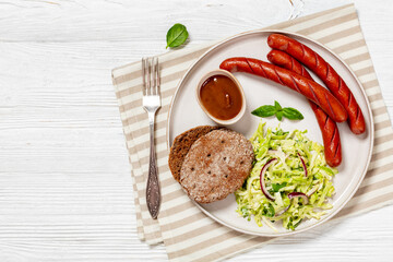 sausages with coleslaw salad, bbq sauce on plate
