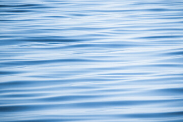 Blue water surface with a pattern of soft waves, background