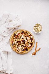 Assortment of nuts and raisins in wooden tray on natural rustic background flat lay