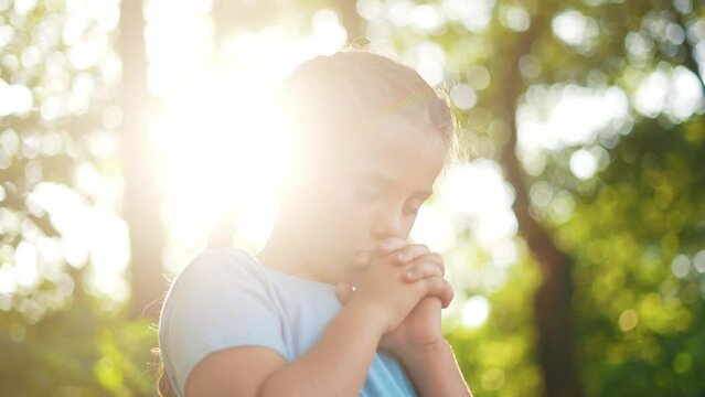 child pray. young gratitude a god religion concept. little lifestyle girl in nature outdoors praying dreams of happiness to god. praise worship freedom concept. kid praying in the forest