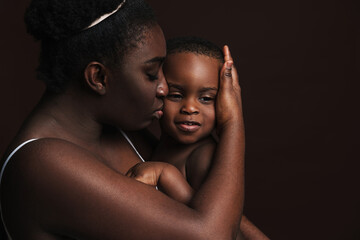 Black young woman hugging and holding her son