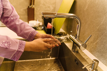 Female hands washing glass bottle to give it for recycling