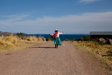 A woman walking down a path in Llachón, near Lake Titicaca in Peru.