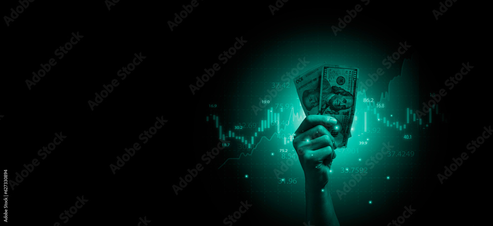 Wall mural Hand holding USD dollar banknote with stock market chart and increasing arrow for dollar exchange , money exchange and inflation interest rating increasing concept.