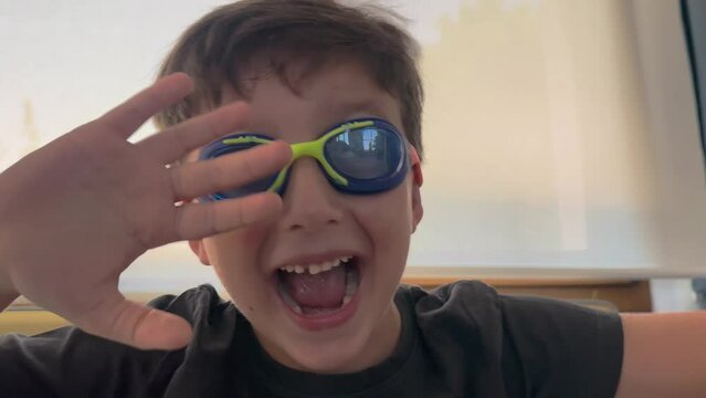 Children with swimming gogles at home. Portrait of happy, young children boy is playing alone at home. Lifestyle concept, laughing.