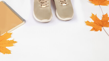 Autumn composition - notepad, sneakers, autumn leaves of an on a white background, flat lay, top...