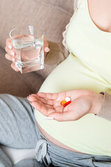 woman holding pill and glass of fresh pure water. Healthy millennial women taking antioxidant medicine vitamins, healthcare concept