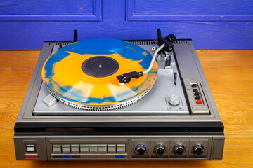 Vintage turntable vinyl record player with blue and orange vinyl