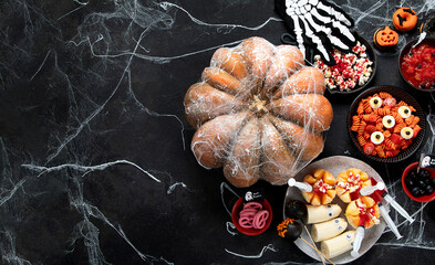 Halloween sweets for Halloween party on black background. top view