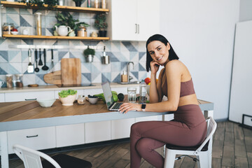 Woman with laptop going to prepare vegetarian meal in kitchen