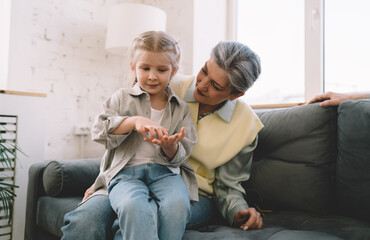 Granddaughter and grandmother sitting together and playing