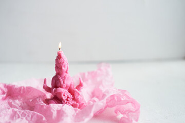 The candle with the goddess Lakshmi is pink. Femininity and fertility. Meditation and Buddhism