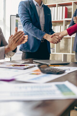 Businessman and businesswoman shaking hands in successful meeting Project partners making cooperation agreement shaking hands while standing in office greeting concept vertical image © ArLawKa