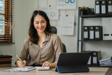 Attractive asian businesswoman doing home office work, asian woman working on tablet, business finance concept