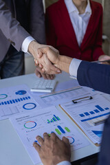 Businessman and businesswoman shaking hands in successful meeting Project partners making cooperation agreement shaking hands while standing in office greeting concept vertical image