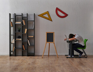 Teenage student sleeping at the lesson, classroom interior, geometric tools, bookshelf and grey wall background