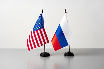 Two little flags of the United States of America and Russia on gray table