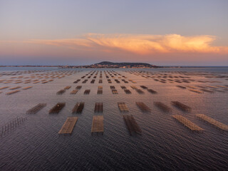 Oyster fields from above at sunset. Sète in the background. Cumulonimbus lit up by last sunlight.